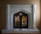The Westminister stone fireplace mantel shown with wrought iron doors.